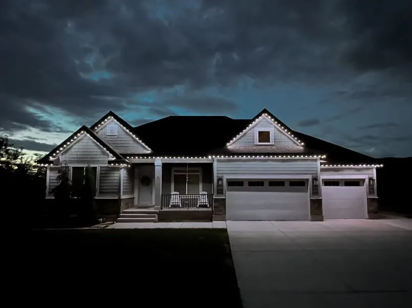Craftsman home with crisp white roofline lighting under a cloudy sky
