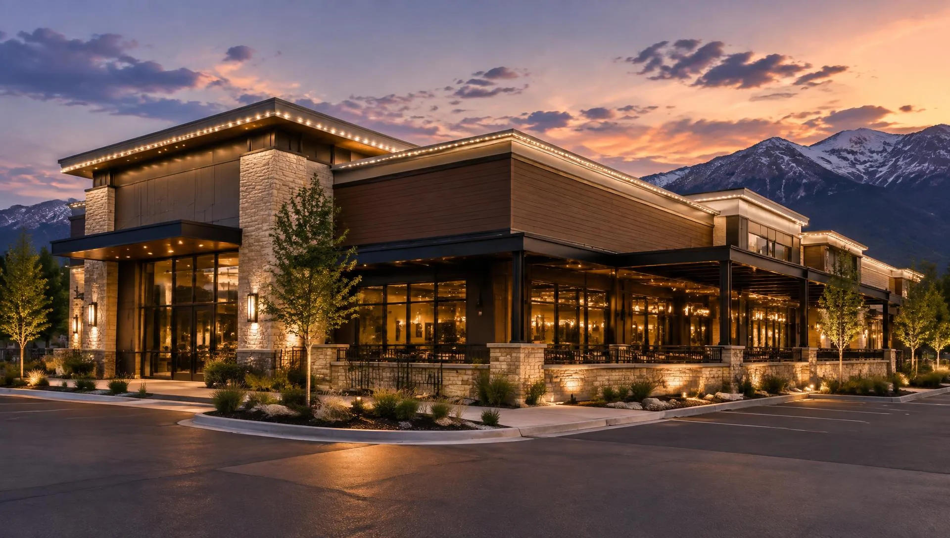 Commercial building at dusk with warm white lighting outlining the roofline