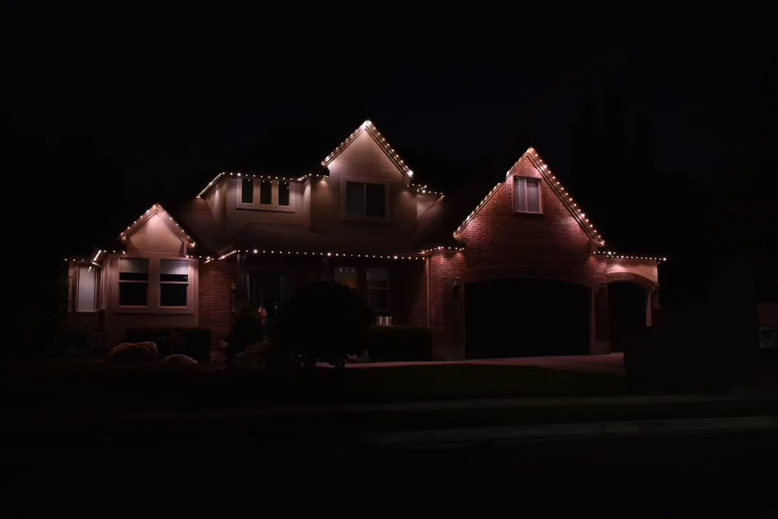 Brick home with soft warm white roofline lights