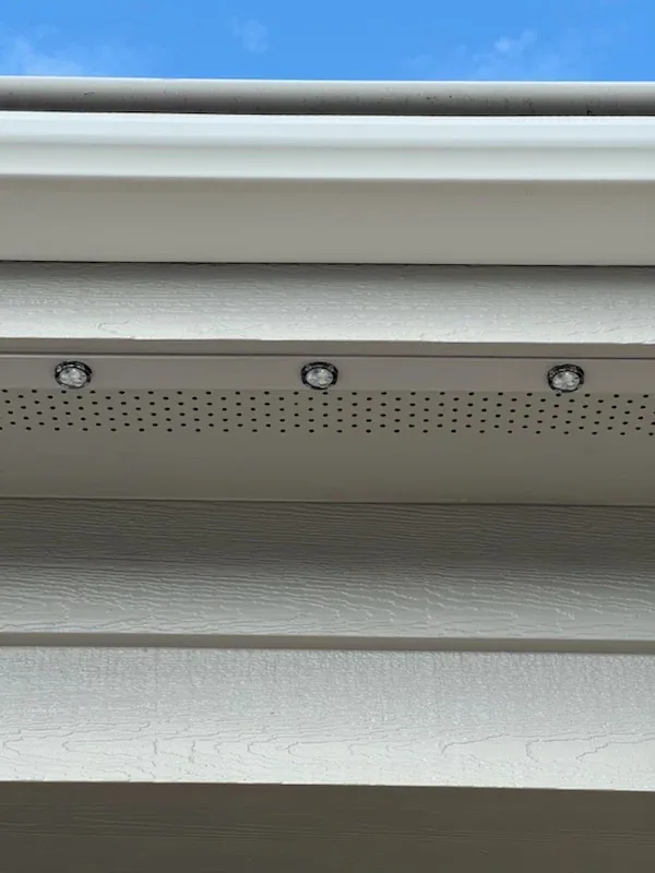 Daytime view of a slim lighting track mounted under the eave, color-matched to the fascia